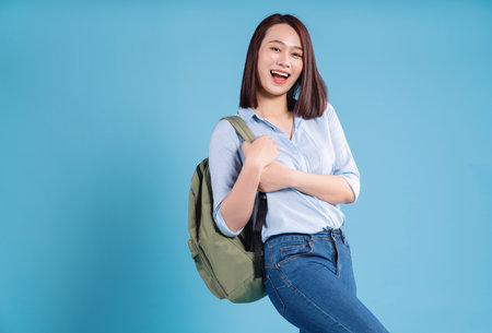 Young Asian student on blue background