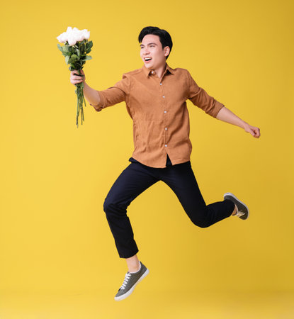 Young Asian man holding flower on backgroundの写真素材