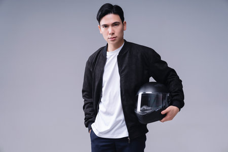 Image of young Asian man with helmet on backgroundの写真素材