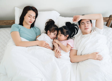 Young Asian family on bedの写真素材