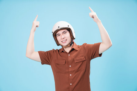 Young Asian man wearing helmet on backgroundの写真素材