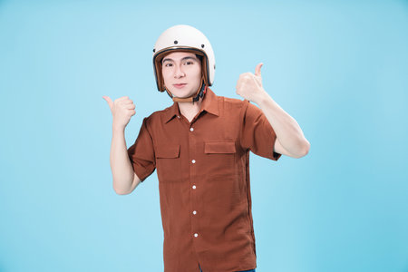 Young Asian man wearing helmet on backgroundの写真素材