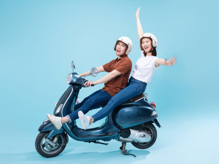 Young Asian couple ride scooter on backgroundの写真素材
