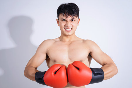 Photo of young Asian boxer on white backgroundの写真素材