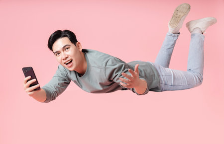 Photo of young Asian man flying on background
