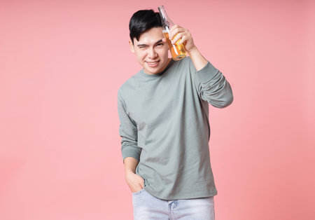 Photo of young Asian man drinking alcohol on backgroundの写真素材