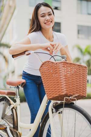 Photo of young Asian woman with bicycleの写真素材