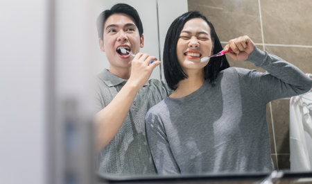 A happy couple enjoys brushing their teeth together, showcasing bright smiles in a contemporary...