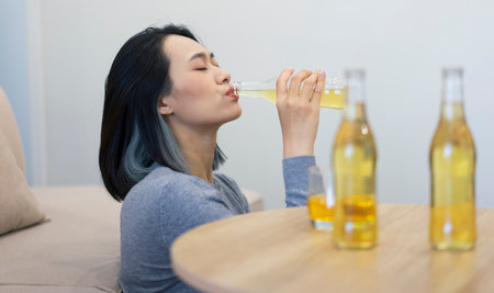 Relaxing in a casual setting, a young woman sips a chilled beverage and enjoys her moment of peace....