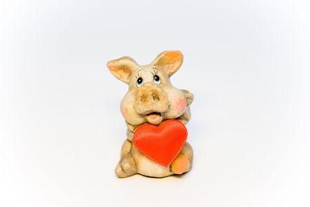 Stone figure of the pig holding red heartの写真素材