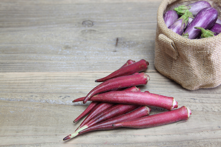 Okra and eggplant in a weooden backgroundの写真素材