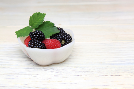 blackberries and raspberries in a bowlの写真素材