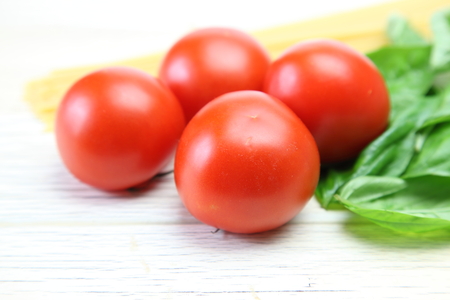 Tomato and basil in a wooden backgroundの写真素材