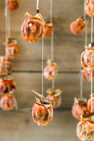 Dried persimmons are suspended by yarnの写真素材