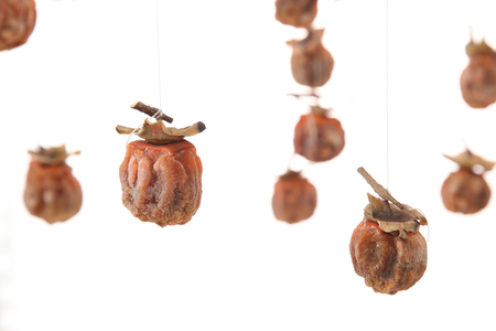 Dried persimmons are suspended by yarnの写真素材