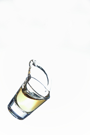 shot glass and liquid in droppingの写真素材