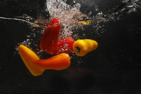 varios color of sweet peppers in the waterの写真素材
