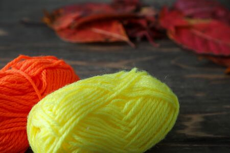 fallen leaves and yarns in a wooden backgroundの写真素材