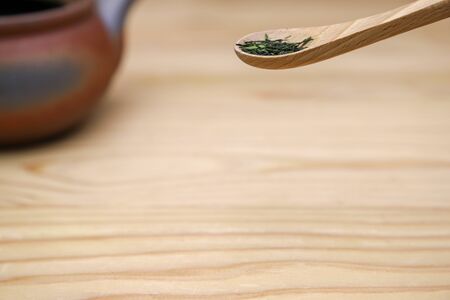 roasted japanese tea leaves on the wooden spoon.