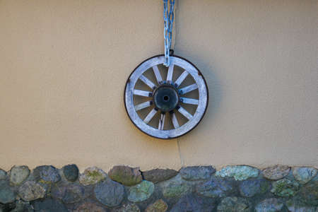 the wooden wheel hung on a clay wallの写真素材