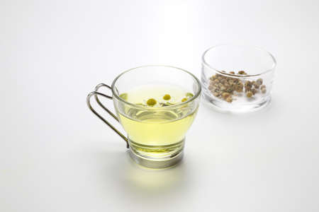 a cup of chamomile tea in a white backgroundの写真素材