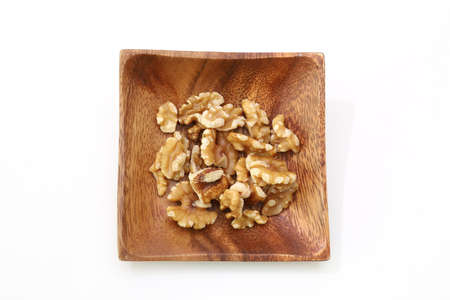 walnuts on the wooden plate isolated a white background