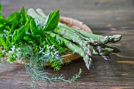 Asparagus and basil on the bamboo colanderの写真素材