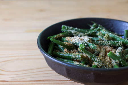 Kidney beans with grind sesame dressing in the bowl isolted on the wooden table.