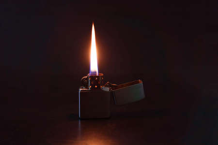 Oil lighter and its flame isolated on a black back ground.