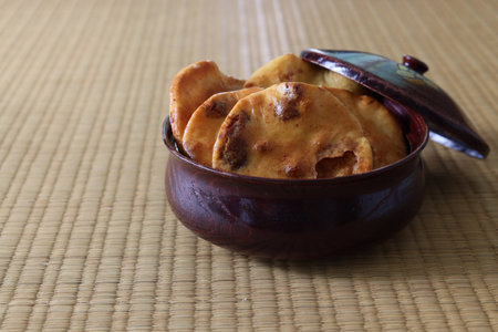japanese rice cracker with soy sauce in the wooden vessel on the tatami mat.