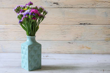 light blue vase and bouquet of Limonium on the wooden tableの写真素材