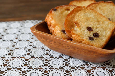 Rusks with chocolate chips on the heart shaped plate on the white wooden table.の写真素材