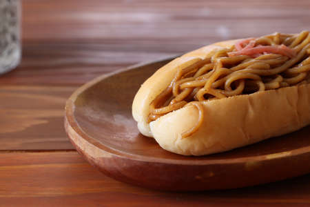 Fried noodle sandwich isolated on the wooden plate.の写真素材