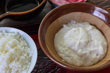 Yam make into a paste in the mortar on the wooden table.