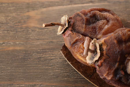 Dried persimmon on the plate on wooden table.の写真素材