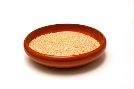 Brown rices in a vermilion crockery isolated in a white background.の写真素材