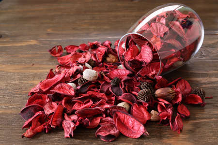 Potpourri in a glass isolated on a wooden table.の写真素材