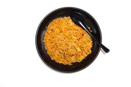 Curry-flavored fried rice on a black dish isolated on a white background.の写真素材