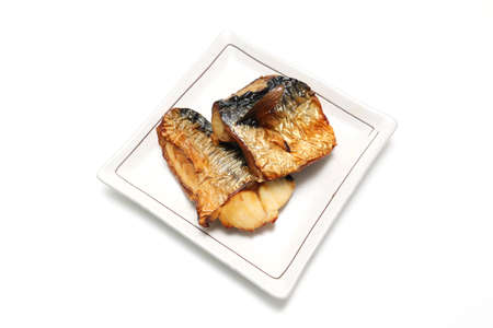 Grilled mackerel with salt on a dish isolated on a white background.