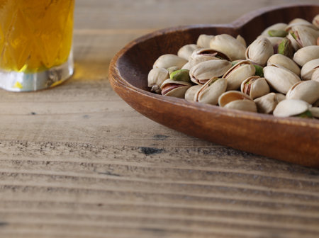 Pistachios on a heart shaped plate on a wooden table.の写真素材