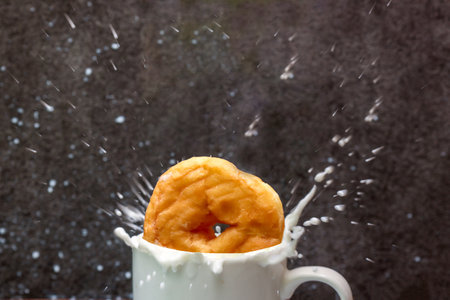 Donut and splashing milk in a cup.