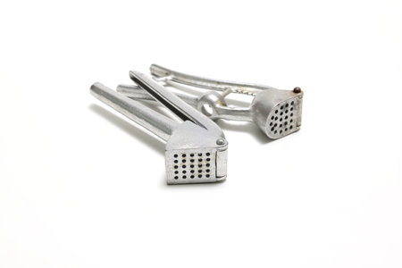 Garlic and garlic press isolated on a white background.