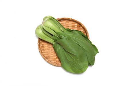 Bok choy on a bamboo colander isolated on a white background.の写真素材