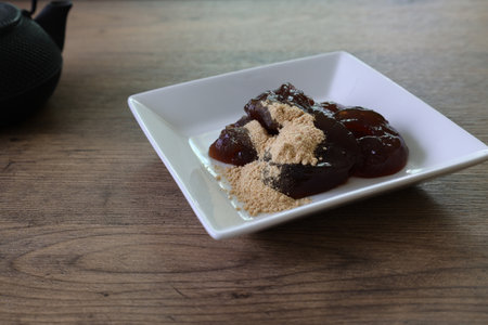 Brown sugar taste warabi mochi with soybean flour on a plate.