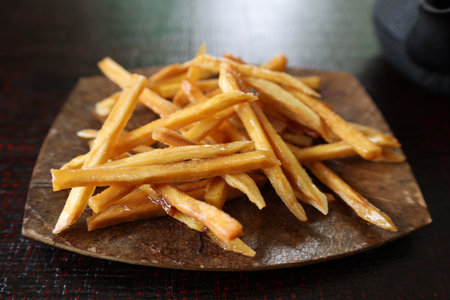 Fried sweet potato coated with sugar on a plate.