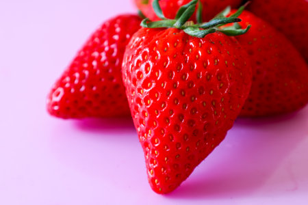 Strawberries isolated on a pink background.