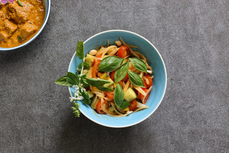 Kachumber in a bowl and curry isolated on a gray background.