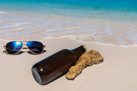 Bottled beer on the sand by the sea.の写真素材