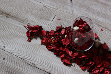 Potpourri in a glass isolated on a wooden table.の写真素材