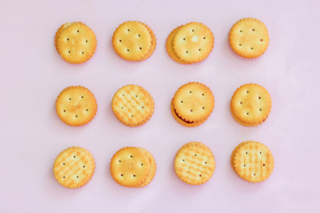 Crackers stuffed with strawberry jam isolated on a pink background.